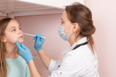 Medical professional taking nasopharynx sample from young girl